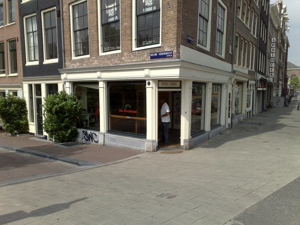 Entrance of the cannabis club near a garden and a pharmacy in Amsterdam